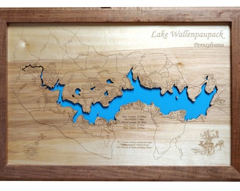 May include: A wooden map of Lake Wallenpaupack in Pennsylvania. The lake is outlined in blue and the surrounding area is shown in brown. The map includes text about the lake's dimensions and a quote about the Lenni Lenape Indians.