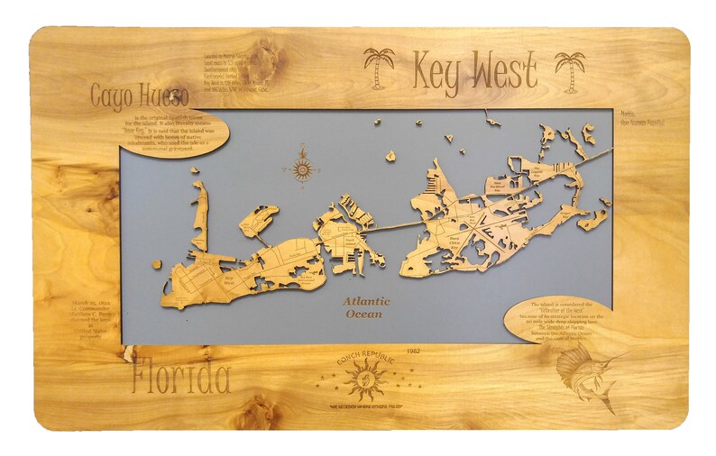 Puede incluir: Un mapa de madera de Cayo Hueso, Florida, con fondo gris. El mapa muestra las calles y los puntos de referencia de la isla. El texto "Key West" est&aacute; escrito en la parte superior del mapa, y el texto "Florida" est&aacute; escrito en la parte inferior. El mapa est&aacute; rodeado por un marco de madera.