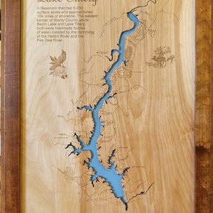 May include: A wooden plaque with a laser-cut map of Lake Tillery, North Carolina. The lake is blue and the surrounding area is brown. The plaque has a text description of the lake, including its size and history.