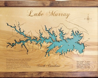 May include: A wooden map of Lake Murray in South Carolina. The lake is outlined in blue and the surrounding area is shown in brown. The map includes text about the lake's history and dimensions, including its maximum length of 41 miles, maximum width of 14 miles, 50,000 surface acres, maximum depth of 200 feet, and 500 miles of shoreline.
