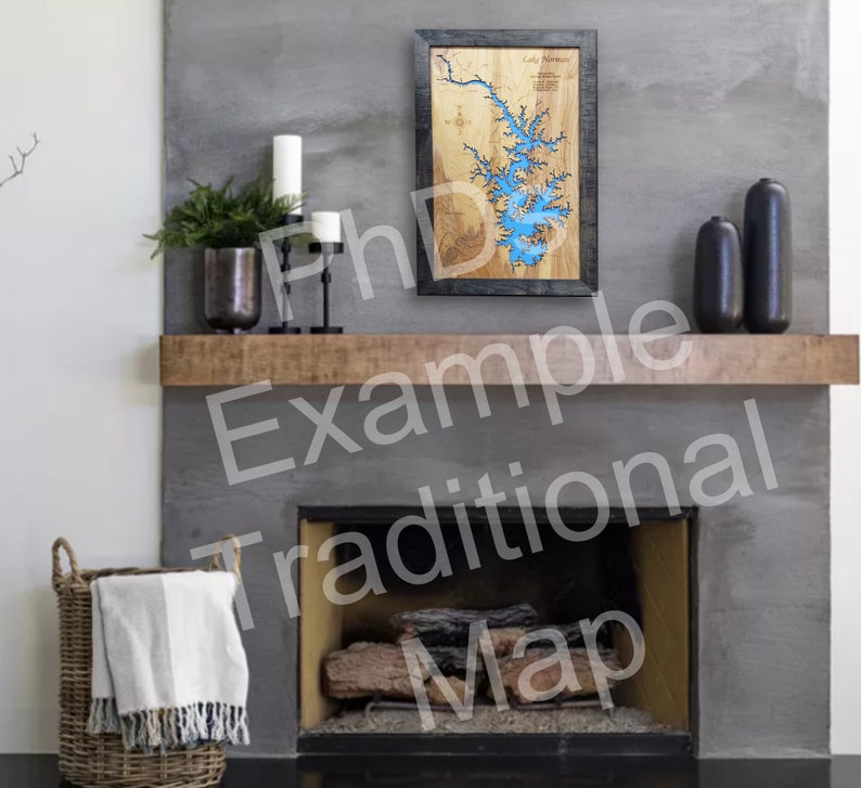 May include: A wooden map of Lake Norman, North Carolina, with a blue water inlay. The map is framed in black and displayed on a mantel above a fireplace.