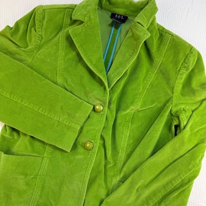May include: A lime green velvet blazer featuring a notched lapel, long sleeves, and two large round buttons on the front closure. The interior lining is visible at the collar, displaying a bright blue vertical stripe and a black R.Q.T. label.