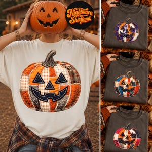 Könnte beinhalten: Ein cremefarbenes T-Shirt mit einer großen Grafik eines Patchwork-Kürbisses mit orangefarbenen, schwarzen und weißen Stoffmustern. Das Design zeigt einen Stiel und ein geschnitztes Gesicht mit dreieckigen Augen und einem breiten, gezackten Lächeln.