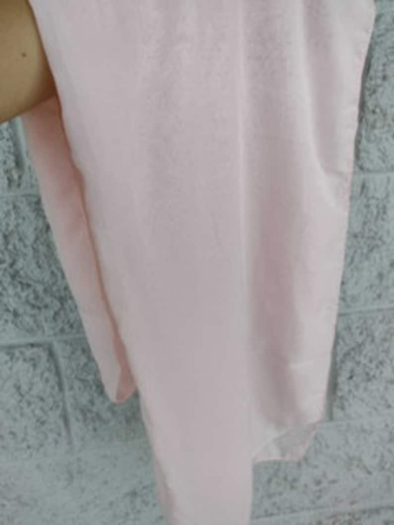 May include: A pale pink fabric swatch, showing the texture and color of the material.