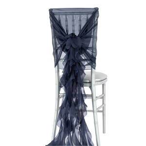 K&ouml;nnte beinhalten: Marineblauer Stuhlschleife mit gerafftem Design. Die Schleife ist um die R&uuml;ckenlehne eines Stuhls gebunden.