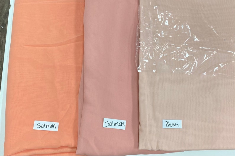 May include: Three swatches of sheer fabric in different shades of pink. The swatches are labeled "Salmon", "Salmon", and "Blush".