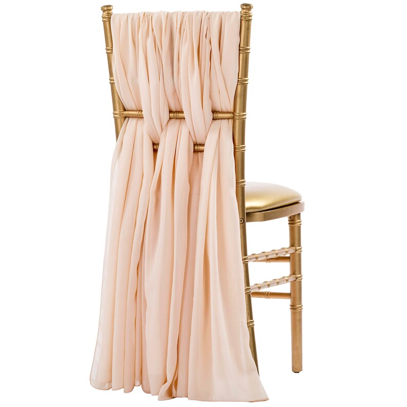 May include: A gold chiavari chair with a blush pink satin sash tied in a bow at the back of the chair.