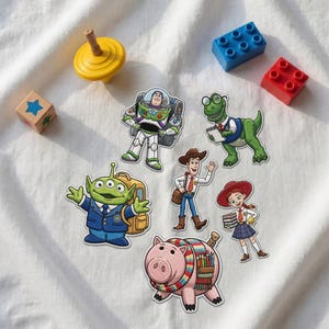 Op de afbeelding: Zes geborduurde patches met Toy Story-personages: Buzz Lightyear, Rex met een bril, een groene alien met een rugzak, Woody, Jessie met boeken en Hamm met een etui. Inclusief een gele tol en twee plastic bouwstenen.