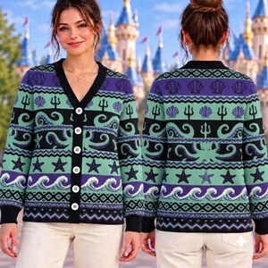 May include: A long-sleeve button-down cardigan featuring a repeating pattern of seashells, tridents, octopuses, starfish, and ocean waves in shades of purple, teal, and black. The garment has a V-neckline and white buttons down the front.