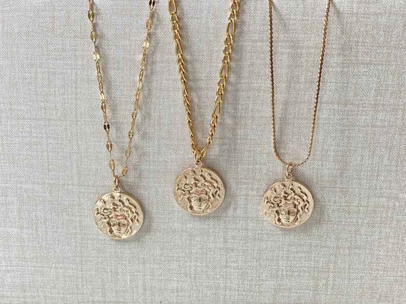 Peut inclure: Trois colliers en or avec un pendentif t&ecirc;te de M&eacute;duse. Chaque collier a un style de cha&icirc;ne diff&eacute;rent.