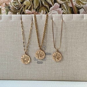 Peut inclure: Trois colliers en or avec diff&eacute;rents styles de cha&icirc;nes et tailles de pendentifs. Les pendentifs sont ronds et pr&eacute;sentent un design d&eacute;taill&eacute;. Les tailles des pendentifs sont de 18 mm et 24 mm.