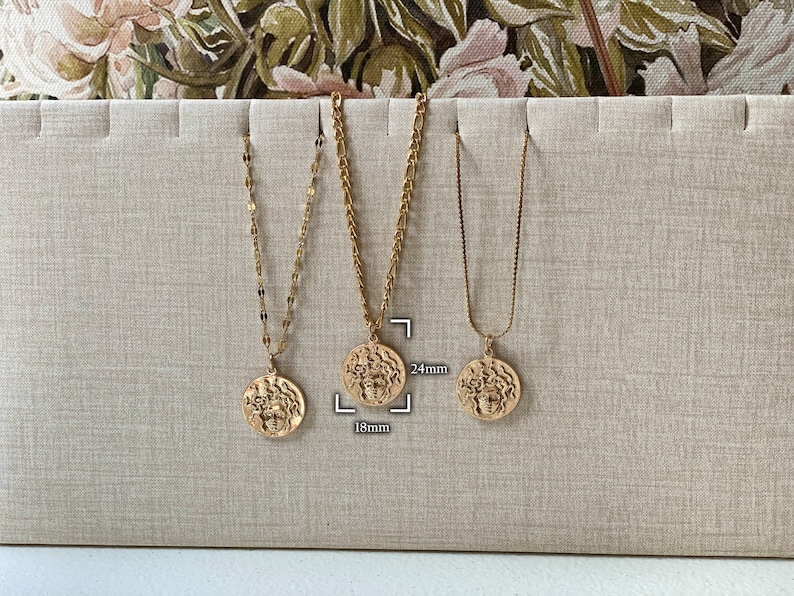 Peut inclure: Trois colliers en or avec diff&eacute;rents styles de cha&icirc;nes et tailles de pendentifs. Les pendentifs sont ronds et pr&eacute;sentent un design d&eacute;taill&eacute;. Les tailles des pendentifs sont de 18 mm et 24 mm.