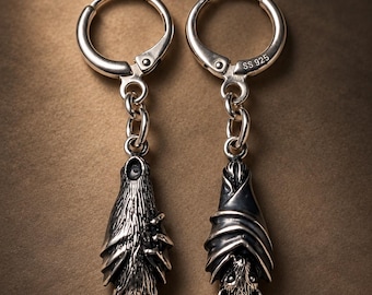 May include: A pair of sterling silver hoop earrings featuring dangling bat charms. Each charm depicts a bat hanging upside down with detailed wings and fur texture. The metal is stamped with SS 925 on the hinge mechanism of the hoop.