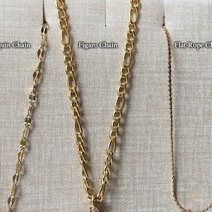 Peut inclure: Gros plan de quatre cha&icirc;nes en or sur un fond en tissu beige. Les cha&icirc;nes sont &eacute;tiquet&eacute;es "Sequin Chain", "Figaro Chain", "Flat Rope Chain".