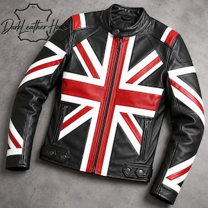 Puede incluir: Una chaqueta de cuero negra con un diseño de bandera Union Jack en rojo y blanco en la parte delantera y las mangas. La chaqueta incluye una cremallera central, un cuello con botón a presión y dos bolsillos con cremallera. El texto Dark Leather House es visible.
