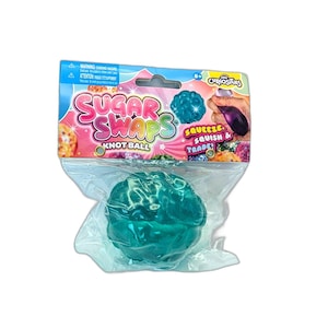 May include: A teal-colored, textured knot ball toy packaged in a clear plastic bag with a cardboard header. The header features the text Sugar Swaps Knot Ball, Squeeze, Squish & Trade!, and Orb Curiosities, along with graphics of the toy.