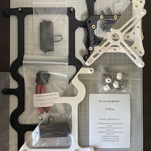 May include: AIO Mount Type A + CPU EPS-Microfit kit containing black and white mounting brackets, a power cable with a label reading FOR AMD BC-250 USE ONLY, a small bag of screws, and a compatibility card listing Thermalright and Corsair models.