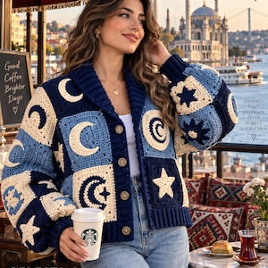 Puede incluir: Un cárdigan de ganchillo en azul marino y crema con un patrón celestial de lunas y estrellas. La prenda tiene cuello de chal, mangas largas y cuatro botones marrones en la parte delantera. El diseño incluye motivos cuadrados con formas.