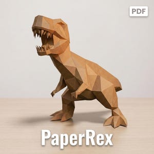 Może przedstawiać: Geometryczna rzeźba typu low-poly przedstawiająca tyranozaura wykonana z brązowego papieru. Figurka dinozaura charakteryzuje się ostrymi, kanciastymi płaszczyznami oraz otwartą paszczą z widocznymi zębami. Słowo PaperRex jest nadrukowane na dole.