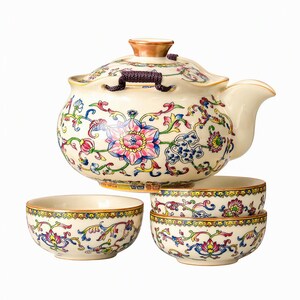 Puede incluir: Una tetera de cerámica con tapa y tres cuencos pequeños a juego, todos con una base de color crema decorada con vibrantes patrones florales multicolores en rosa, azul, verde y amarillo, con un asa trenzada de color morado oscuro en la tapa.