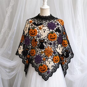 May include: A black crocheted poncho featuring an intricate openwork net pattern adorned with various Halloween-themed motifs including orange pumpkins, white ghosts, black cats, purple spiderwebs, and small orange stars throughout the garment.