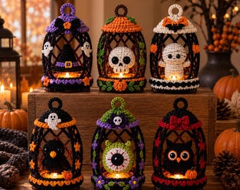 Op de afbeelding: Zes gehaakte lantaarn-ornamenten met Halloween-thema's. Elke kooi bevat een figuur: een heksenhoed, een schedel, een mummie, een zwarte vogel, een groene oogbol en een uil, versierd met kleine bloemen, strikjes en pompoenen.