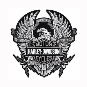 May include: A black and white embroidered patch featuring a central eagle with spread wings. The design includes the text SINCE 1903, LEGENDARY, MOTORCYCLES, and the Harley-Davidson Motor Cycles logo. Two lightning bolts extend from the eagle's talons.