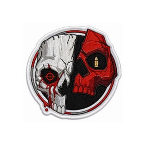 Puede incluir: Un parche bordado circular con un diseño de cráneo dividido. El lado izquierdo es blanco con una mira roja sobre el ojo y detalles rojos que gotean. El lado derecho es rojo con un icono de bala dorada. El fondo es de color negro.