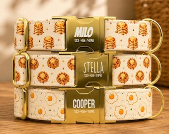 May include: Three pet collars with gold-tone metal buckles. The top collar features a pancake pattern with the name MILO and 123-456-7890. The middle collar has a waffle pattern with the name STELLA and 123-456-7890. The bottom collar has an egg pattern with the name COOPER and 123-456-7890.