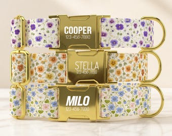 May include: Three pet collars with floral patterns in purple, orange, and blue. Each features a gold-tone metal buckle engraved with a name and phone number: COOPER 123-456-7890, STELLA 123-456-7890, and MILO 123-456-7890, plus gold-tone metal hardware.