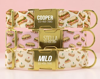 May include: Three pet collars with gold-tone metal buckles and hardware. Each buckle is engraved with a name and phone number: COOPER 123-456-7890, STELLA 123-456-7890, and MILO 123-456-7890. The fabric straps feature colorful sandwich patterns.