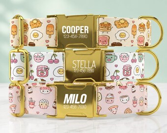 May include: Three pet collars with gold-tone metal buckles engraved with names and phone numbers. The top collar features a breakfast pattern, the middle has a cherry and egg print, and the bottom displays a food-themed design on pink fabric.