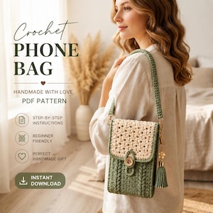 May include: A crochet phone bag featuring a sage green body with a cable knit texture and a cream-colored flap with a floral pattern. The bag includes a matching shoulder strap, a wooden button closure, and a gold-toned tassel charm with a flower.