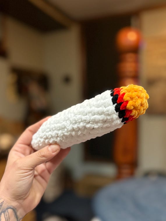 A meticulously crocheted joint — the audacity of making yarn weed this convincing is genuinely funny.
