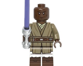 May include: A dark-skinned LEGO minifigure wearing a tan tunic with a brown belt and dark brown boots. The figure has a serious facial expression and is holding a silver-handled lightsaber with a translucent purple blade in its right hand.