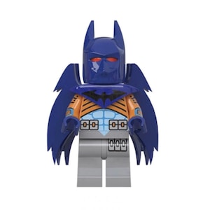 May include: A plastic toy minifigure featuring a dark blue cowl with pointed ears and red eyes. The torso displays orange and light blue armor plating with black accents. A dark blue cape with jagged edges extends from the shoulders, and the legs are solid gray.
