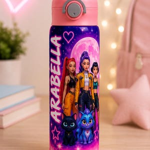 Könnte beinhalten: Eine zylindrische Wasserflasche mit rosa Deckel und Boden, die einen violetten und rosafarbenen kosmischen Hintergrund aufweist. Das Design zeigt drei animierte Figuren, zwei Katzen, einen großen Mond und den Namen ARABELLA in weißen Buchstaben.