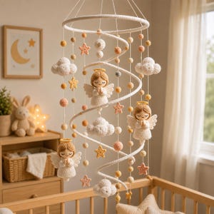 Peut inclure: Un mobile pour bébé en crochet composé de trois anges avec des auréoles dorées et des ailes blanches, entremêlés de nuages blancs et de petites étoiles jaunes et pêche. Les éléments sont suspendus à un cadre circulaire blanc.