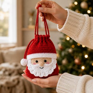 Può includere: Una pochette con coulisse lavorata all'uncinetto in rosso e bianco, disegnata per assomigliare a Babbo Natale. La pochette presenta un corpo rosso, un bordo bianco, una barba bianca, un naso piccolo, occhi neri e un pompon bianco.