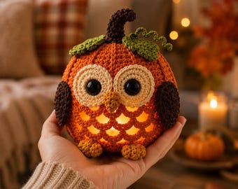 May include: A crocheted pumpkin-shaped owl figure in orange, dark brown, and green yarn. The owl features large black eyes, a small beak, and a hollow, open-stitch belly that glows with an internal light. It has two dark brown wings and small feet.