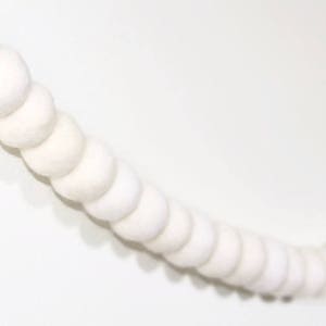 May include: A white felt ball garland, a string of white pom poms connected together, perfect for adding a touch of whimsy to any space.
