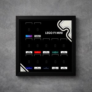 Puede incluir: Un tablero de exhibición con marco negro titulado LEGO F1 MINI que presenta un diseño de cuadrícula con espacios vacíos para etiquetas rectangulares pequeñas. El tablero incluye varios logotipos y nombres de equipos de Fórmula 1.