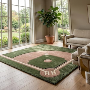 May include: A rectangular area rug featuring a tufted design of a baseball field. The rug displays a green outfield, a tan infield, white base paths, and a home plate area with white markings, all set against a light-coloured wooden floor.