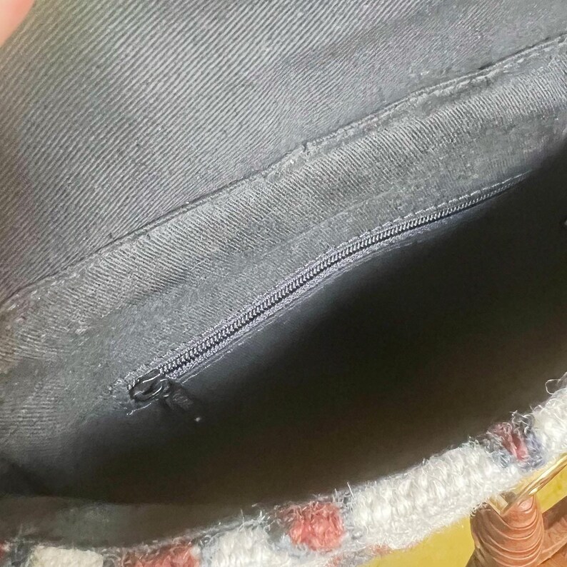 K&ouml;nnte beinhalten: Das Innere einer schwarzen Stofftasche mit Rei&szlig;verschluss. Die Tasche ist mit schwarzem Stoff gef&uuml;ttert. Die Tasche hat ein gewebtes Muster auf der Au&szlig;enseite.