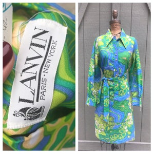 Pode incluir: Um vestido vintage de manga comprida, colarinho e cinto com padr&atilde;o verde, azul e branco. O vestido tem uma etiqueta que diz "LANVIN PARIS NEW YORK".
