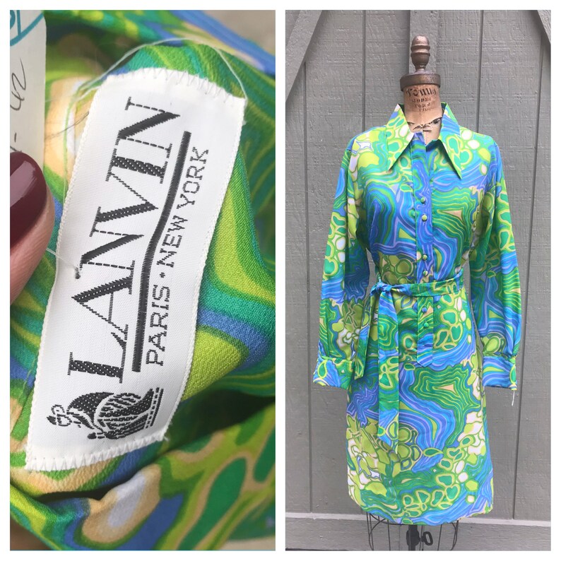 Pode incluir: Um vestido vintage de manga comprida, colarinho e cinto com padr&atilde;o verde, azul e branco. O vestido tem uma etiqueta que diz "LANVIN PARIS NEW YORK".