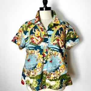 May include: A short-sleeved button-up shirt with a tropical print featuring palm trees, flowers, and people in a beach scene. The shirt is green, blue, yellow, and red.