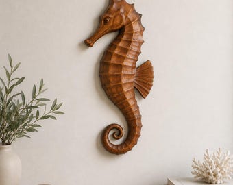 May include: A wall-mounted seahorse sculpture carved from medium-brown wood. The seahorse features a textured, segmented body, a curved tail, and a prominent dorsal fin. The surface displays natural wood grain patterns and a smooth, polished finish.