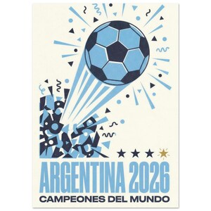 May include: A graphic print featuring a soccer ball in flight with light blue and dark blue geometric shapes and confetti. Below the ball, the text reads ARGENTINA 2026 and CAMPEONES DEL MUNDO, accompanied by three dark blue stars and one gold star.