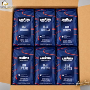 Könnte beinhalten: Ein Karton mit sechs Packungen Lavazza Gran Espresso Kaffeebohnen. Jede dunkelblaue Packung zeigt rote geschwungene Linien, das Lavazza-Logo sowie Hinweise auf Kakao- und schwarze Pfeffernoten mit einem Nettogewicht von 1000g.